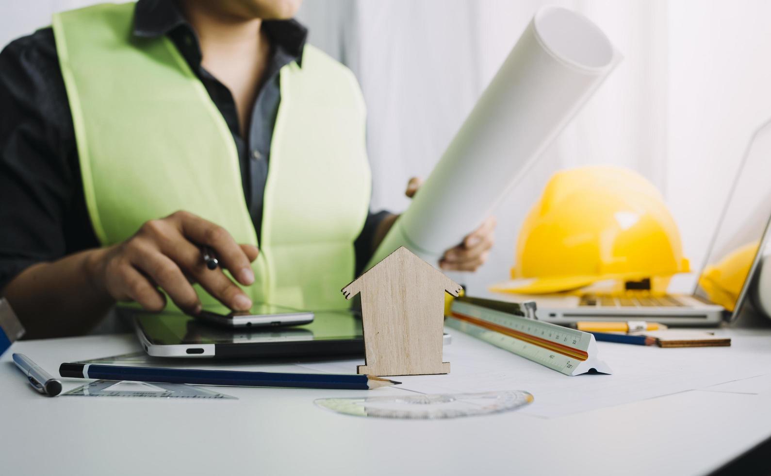 business hand working and laptop with on on architectural project at construction site at office desk in office photo