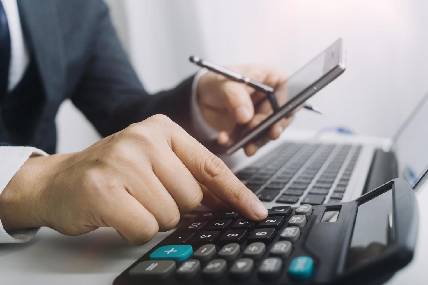 Business accounting concept, Business man using calculator with computer laptop, budget and loan paper in office. photo