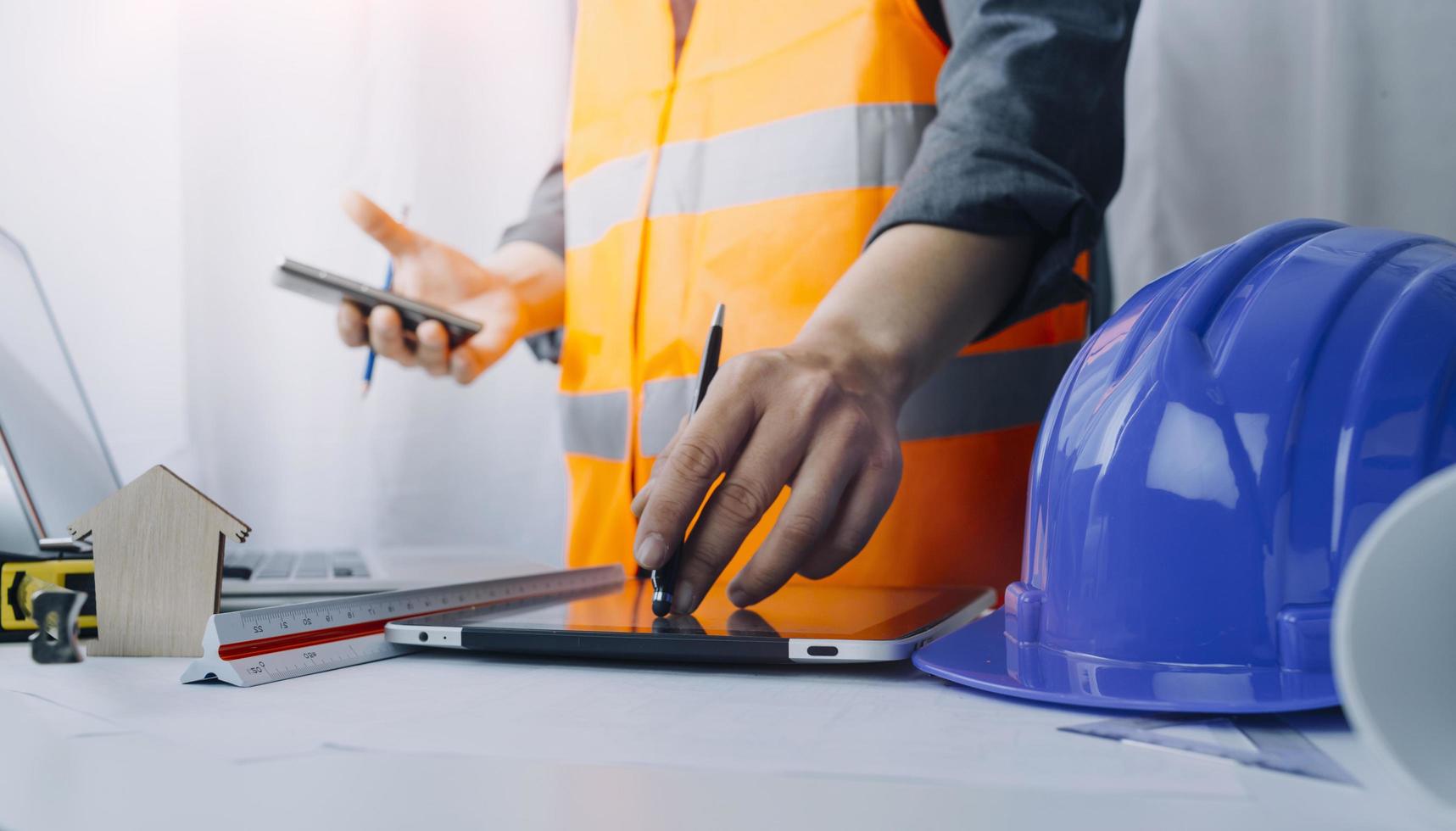 business hand working and laptop with on on architectural project at construction site at office desk in office photo