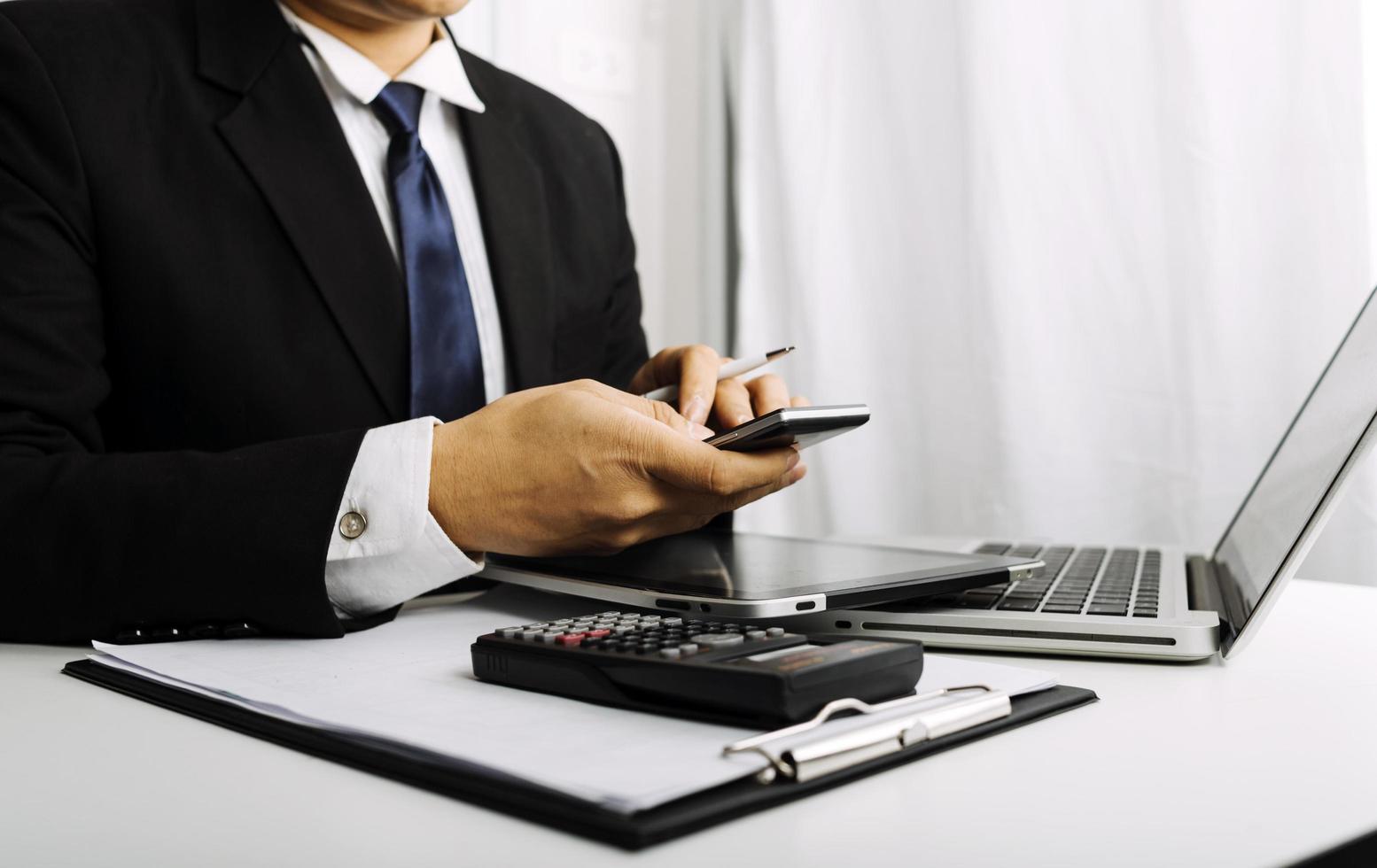 Business accounting concept, Business man using calculator with computer laptop, budget and loan paper in office. photo