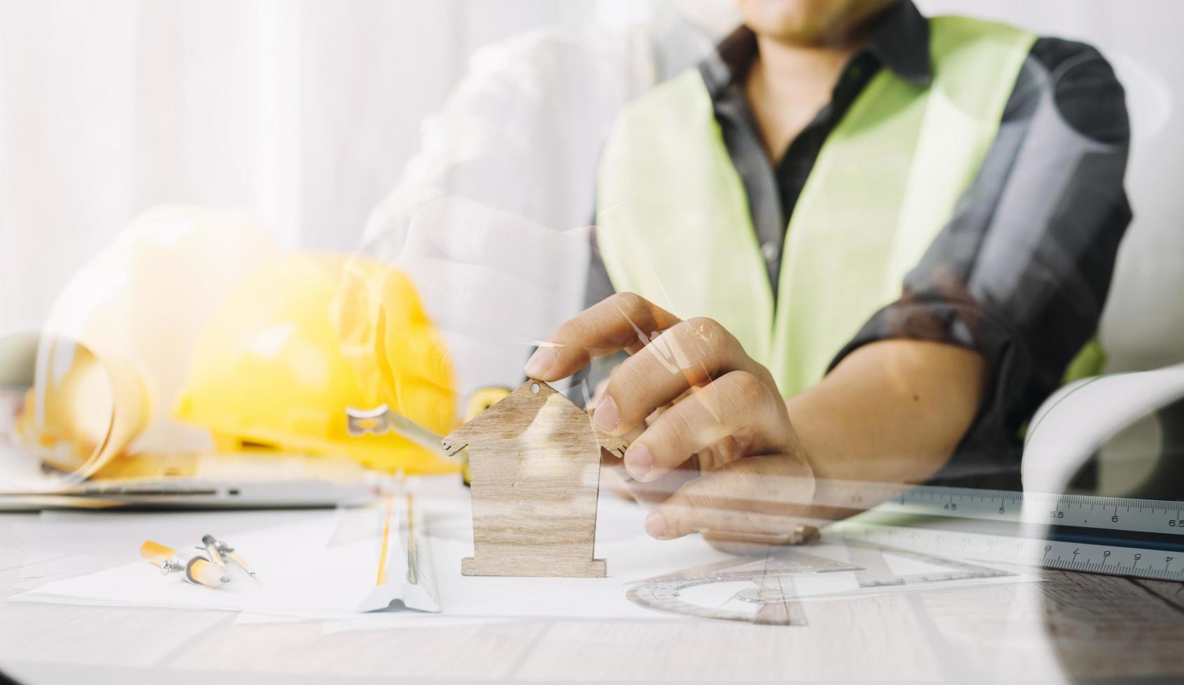 business hand working and laptop with on on architectural project at construction site at office desk in office photo