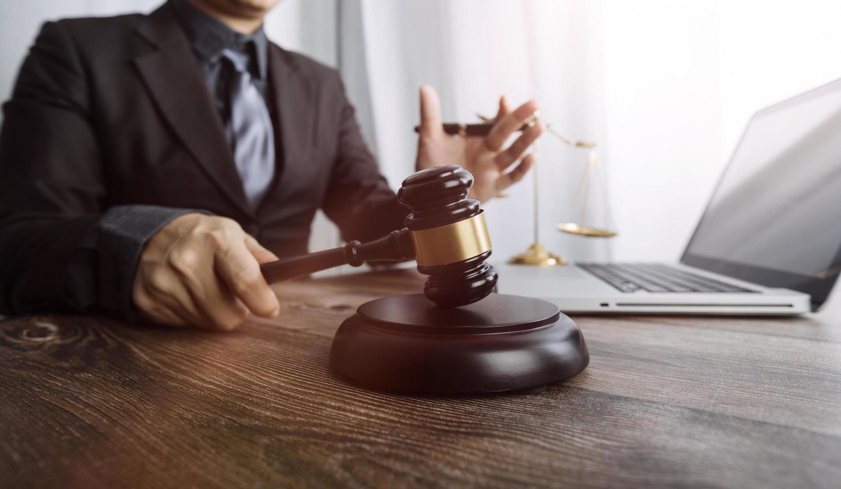 Business and lawyers discussing contract papers with brass scale on desk in office. Law, legal services, advice, justice and law concept picture with film grain effect photo