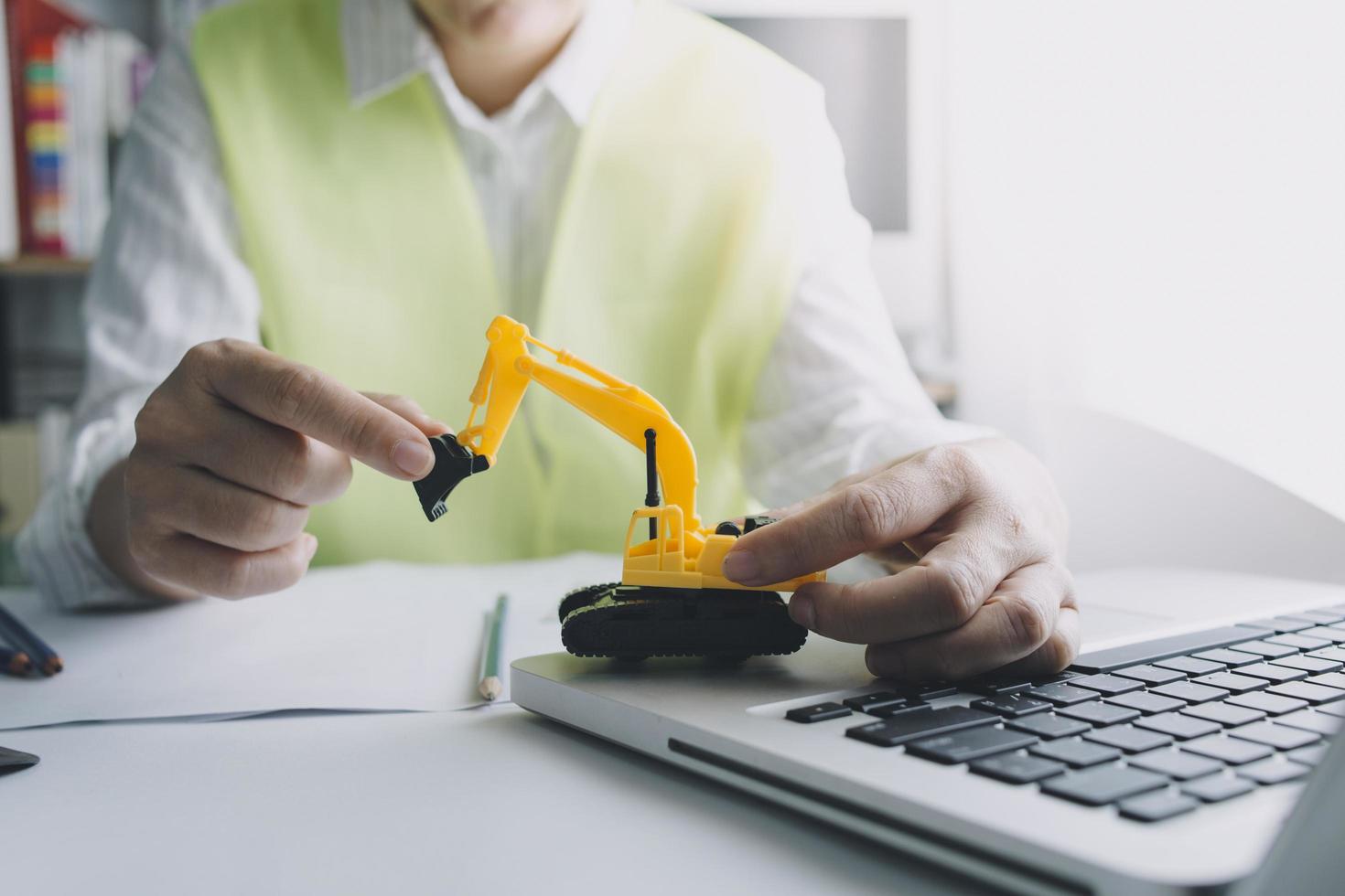 Two colleagues discussing data working and tablet, laptop with on on architectural project at construction site at desk in office photo