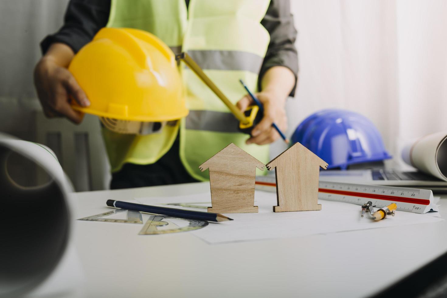 Two colleagues discussing data working and tablet, laptop with on on architectural project at construction site at desk in office photo