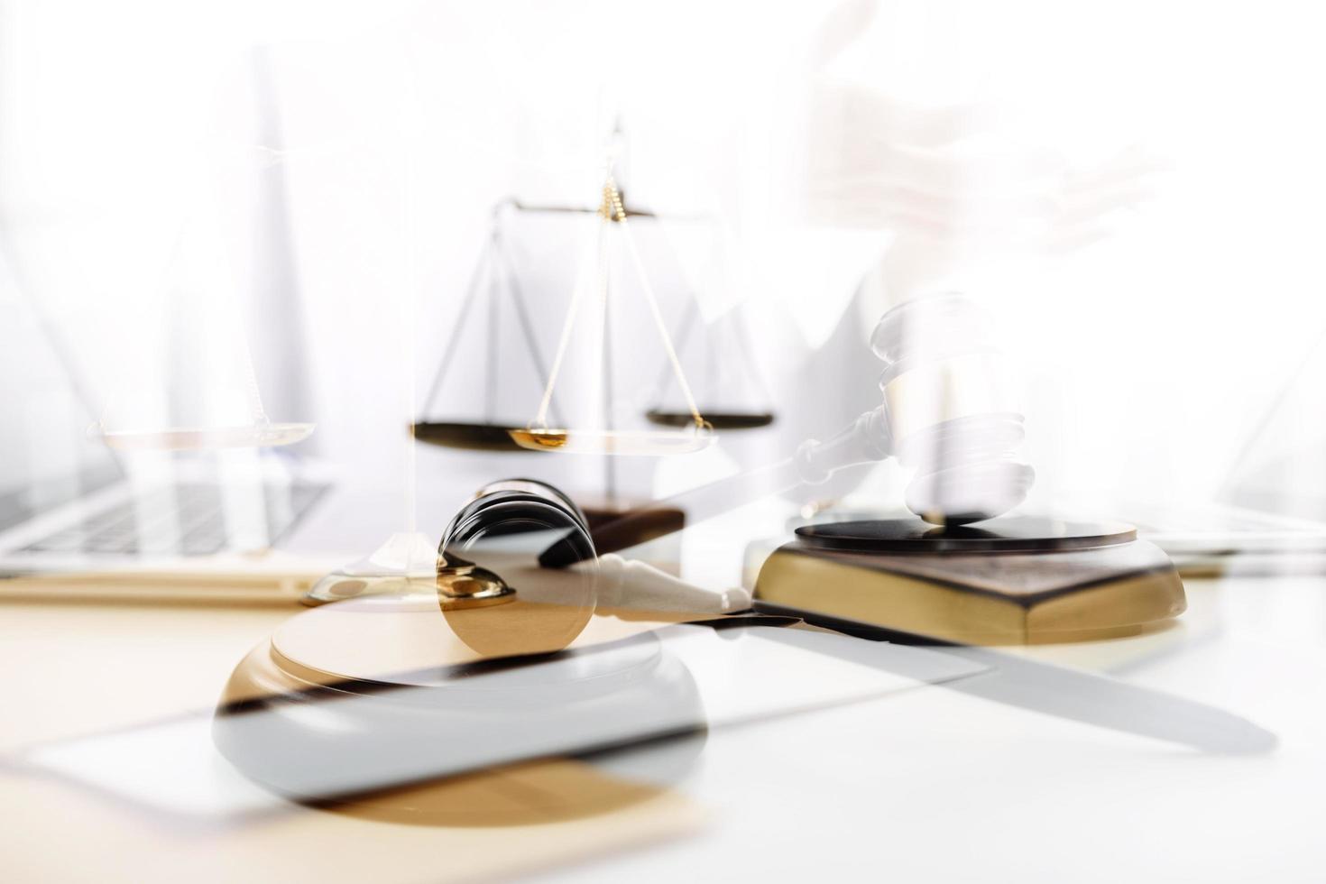 Justice and law concept.Male judge in a courtroom with the gavel, working with, computer and docking keyboard, eyeglasses, on table in morning light photo