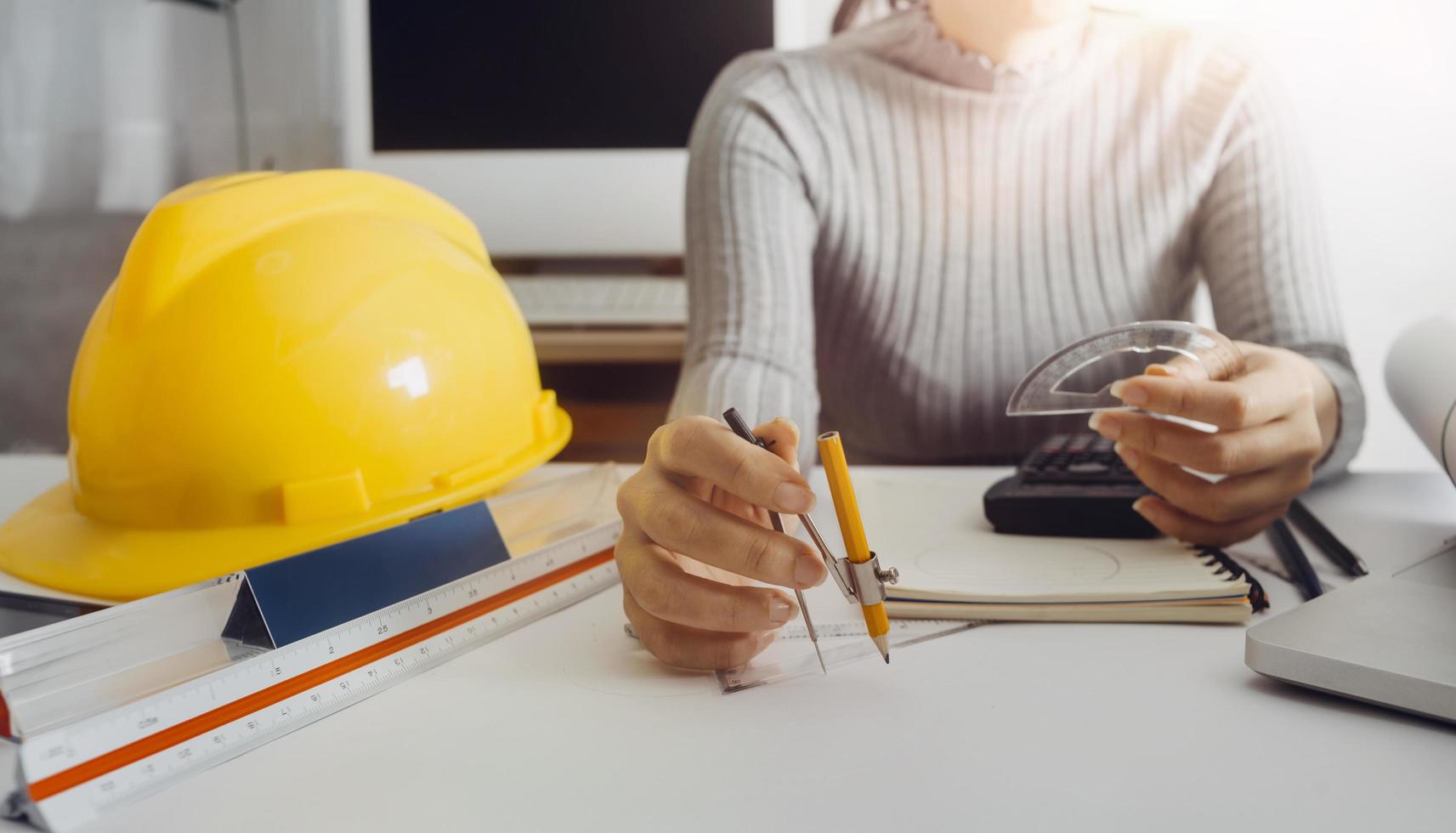 business hand working and laptop with on on architectural project at construction site at office desk in office photo