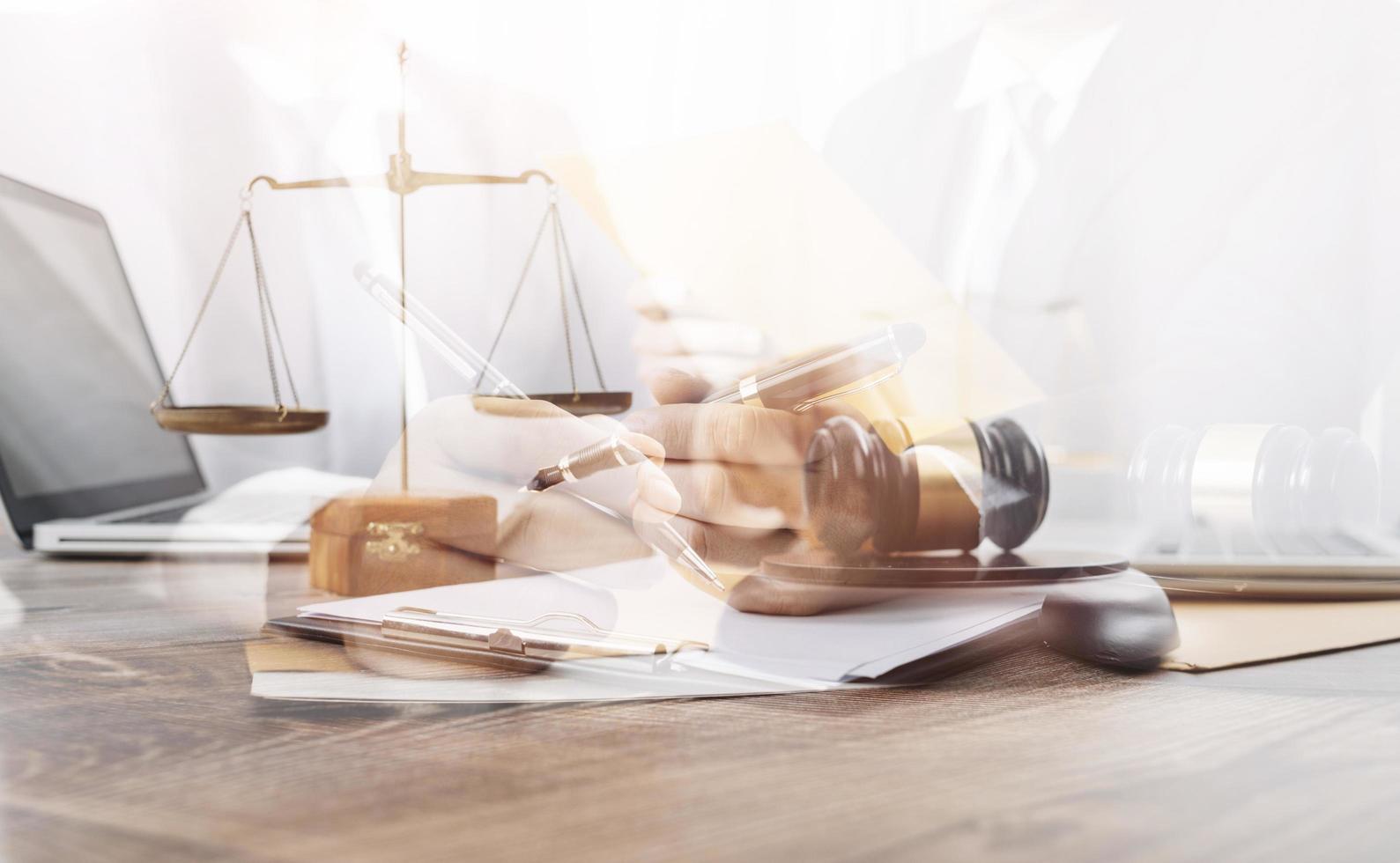 Justice and law concept.Male judge in a courtroom with the gavel, working with, computer and docking keyboard, eyeglasses, on table in morning light photo