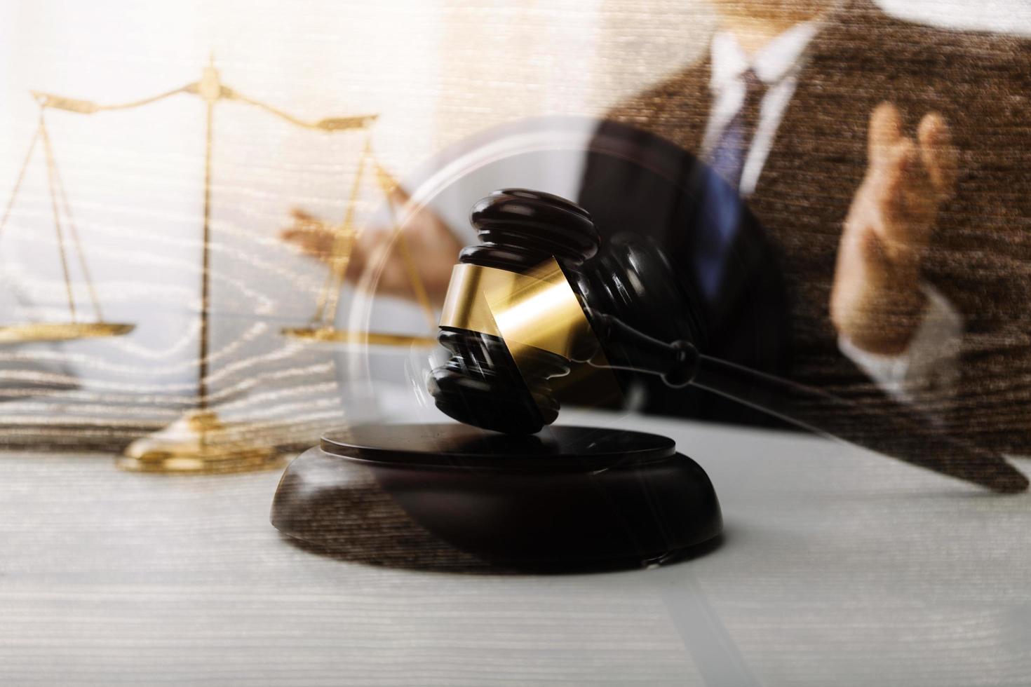 Justice and law concept.Male judge in a courtroom with the gavel, working with, computer and docking keyboard, eyeglasses, on table in morning light photo