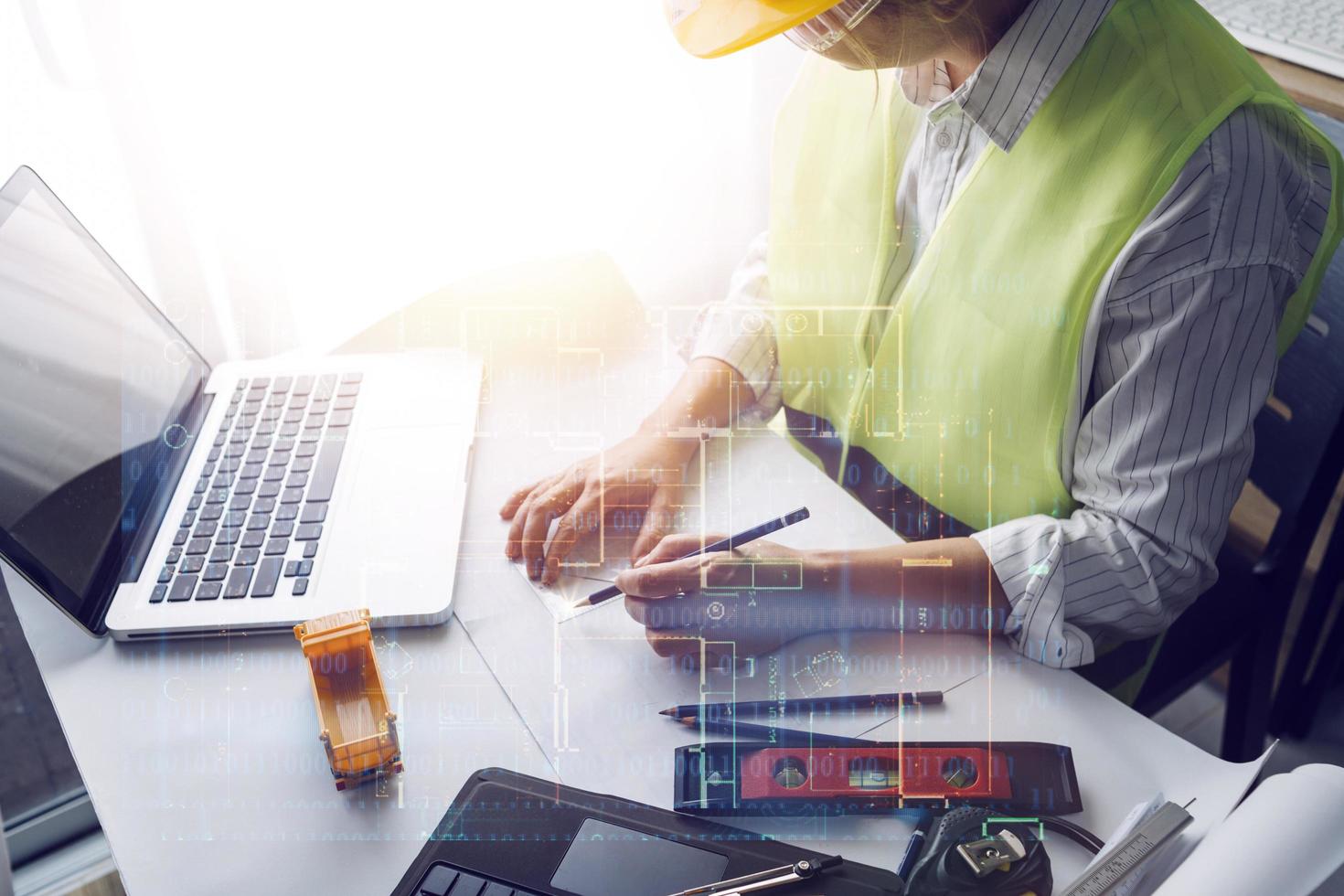 business hand working and laptop with on on architectural project at construction site at office desk in office photo
