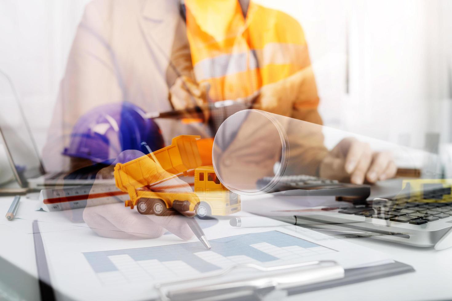 business hand working and laptop with on on architectural project at construction site at office desk in office photo