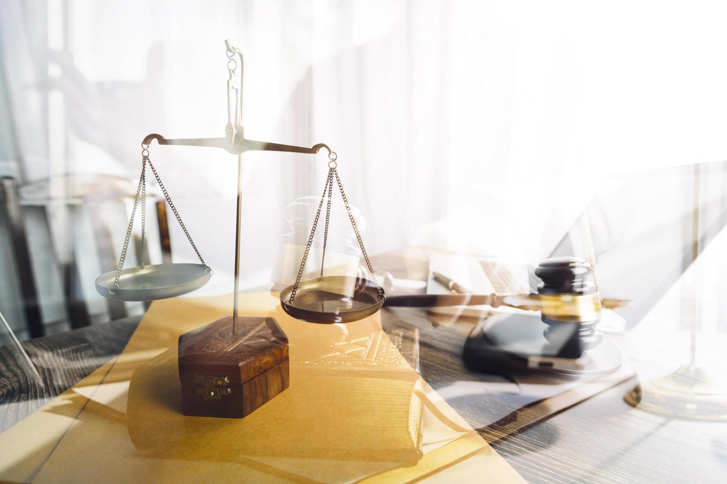 Business and lawyers discussing contract papers with brass scale on desk in office. Law, legal services, advice, justice and law concept picture with film grain effect photo