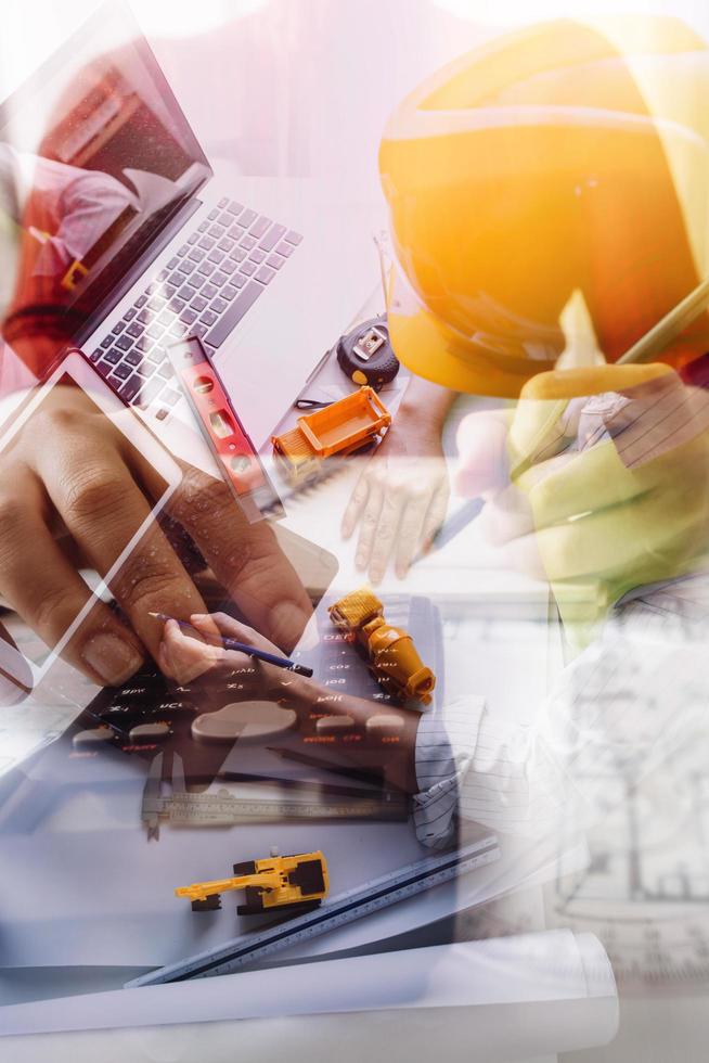 business hand working and laptop with on on architectural project at construction site at office desk in office photo