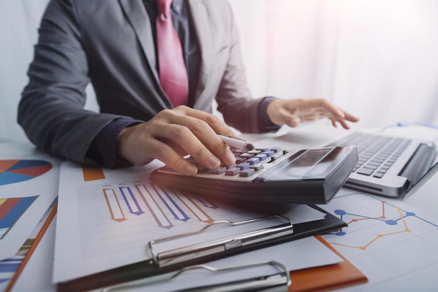 Business accounting concept, Business man using calculator with computer laptop, budget and loan paper in office. photo