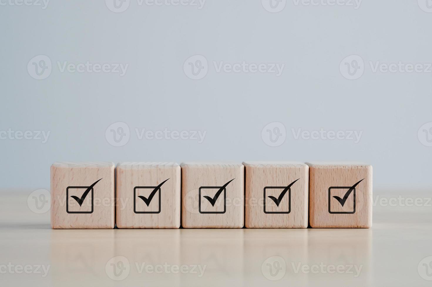 Checklist Survey and assessment. Quality Control. Goals achievement and business success. Check mark icon on wooden blocks. photo