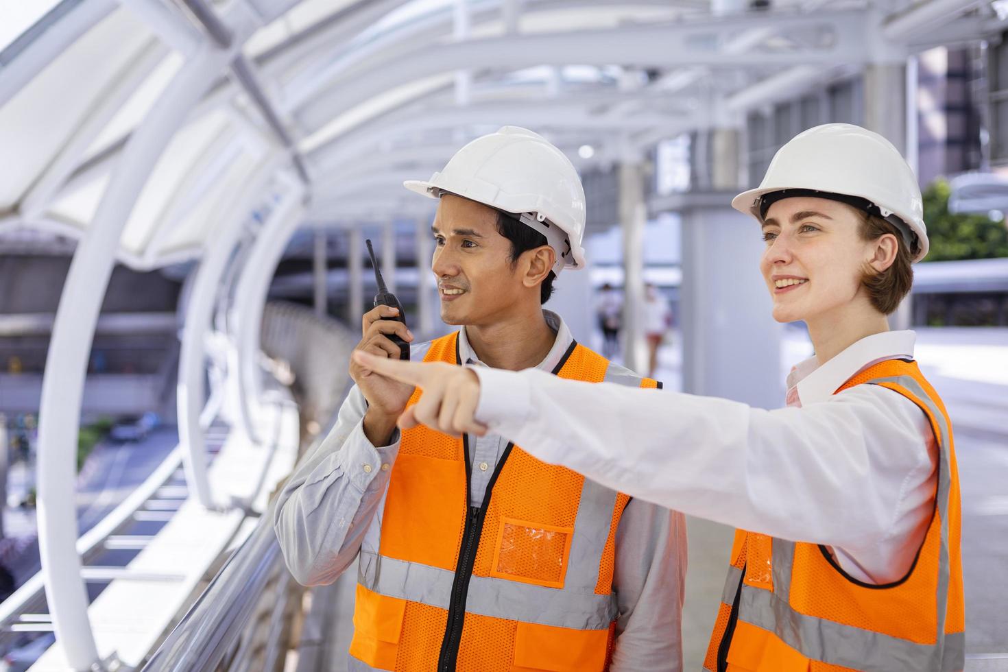 Team of diversity engineer is using walkie talkie while inspecting the construction project for modern architecture and real estate development concept photo