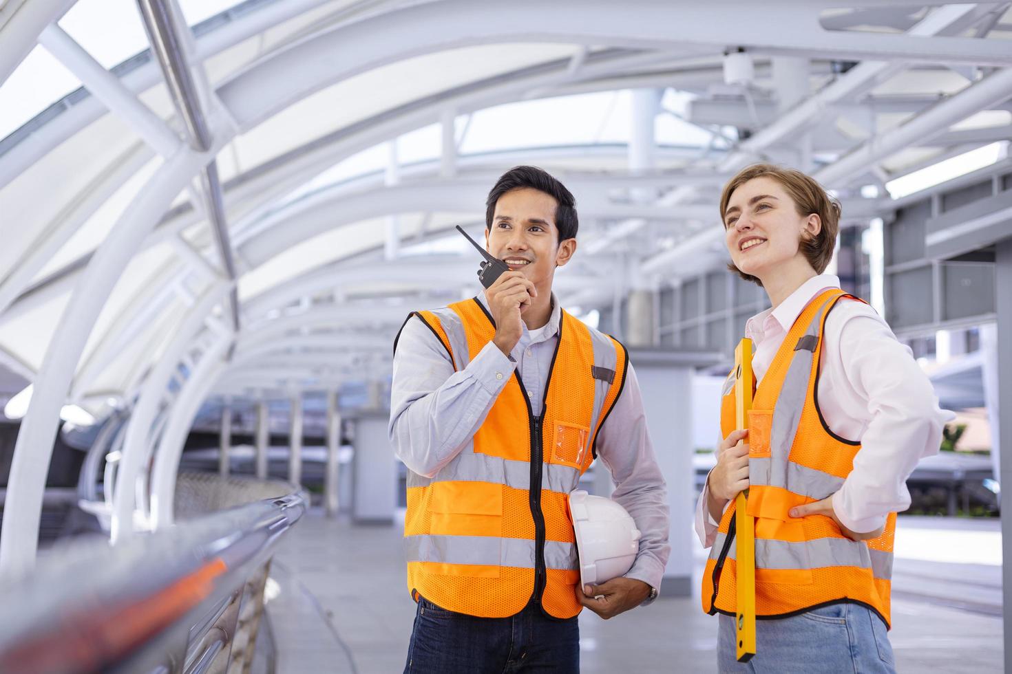 el equipo de ingenieros de diversidad está usando walkie talkie mientras inspecciona el proyecto de construcción para la arquitectura moderna y el concepto de desarrollo inmobiliario foto