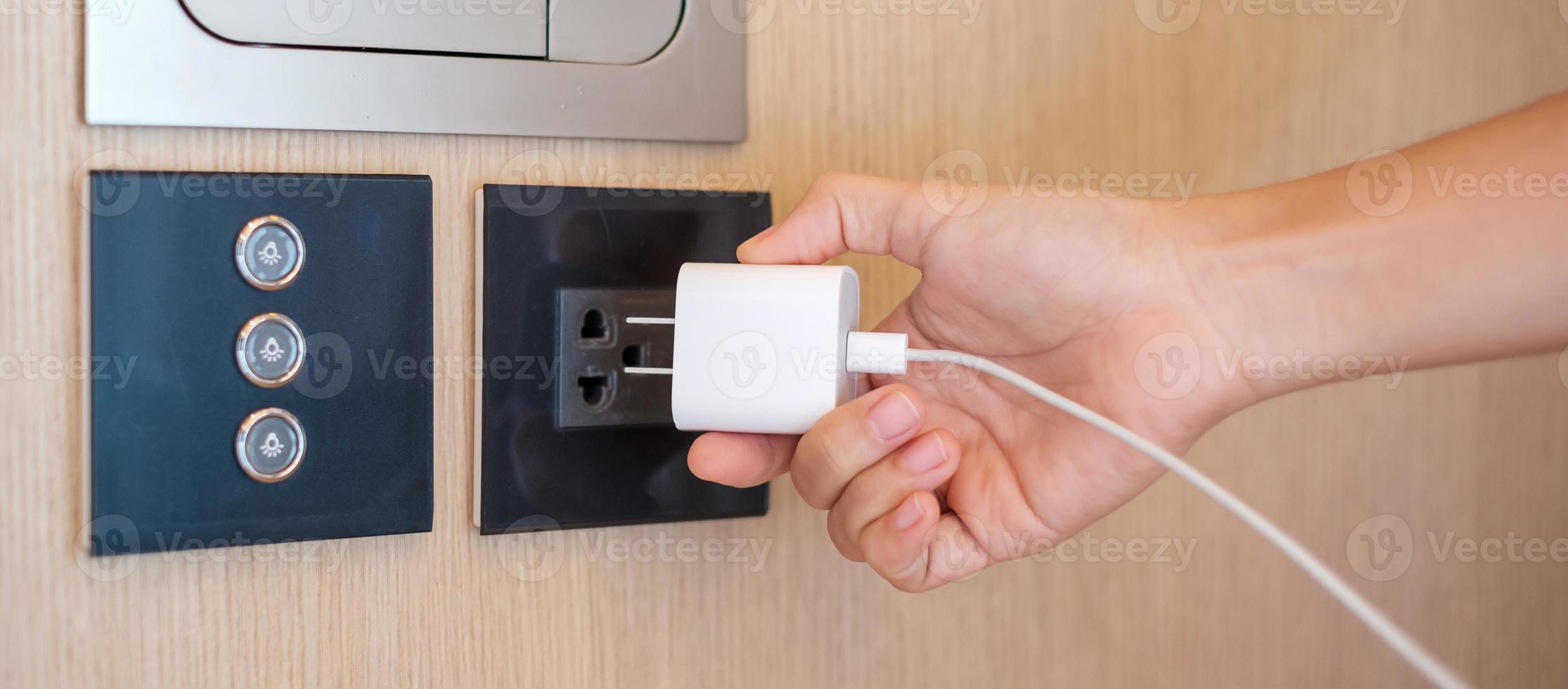 Closeup finger unplugging or plugging of electricity device at home. Energy Saving, power, electrical and lifestyle concepts photo