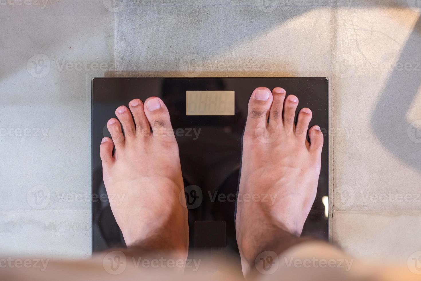 Man stand on the digital weight scale. Diet, weight loss, overweight, obesity and health concept photo