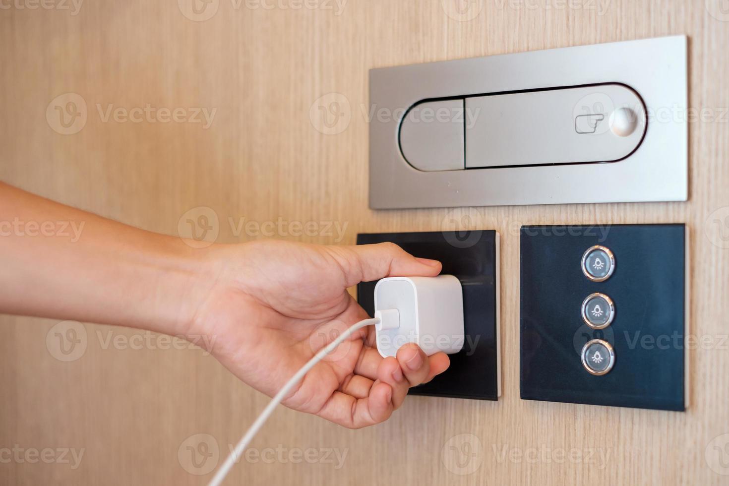 Closeup finger unplugging or plugging of electricity device at home. Energy Saving, power, electrical and lifestyle concepts photo