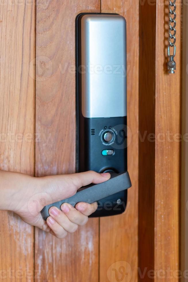 man holding handle of smart digital door lock while open or close the door. Technology, electrical and lifestyle concepts photo