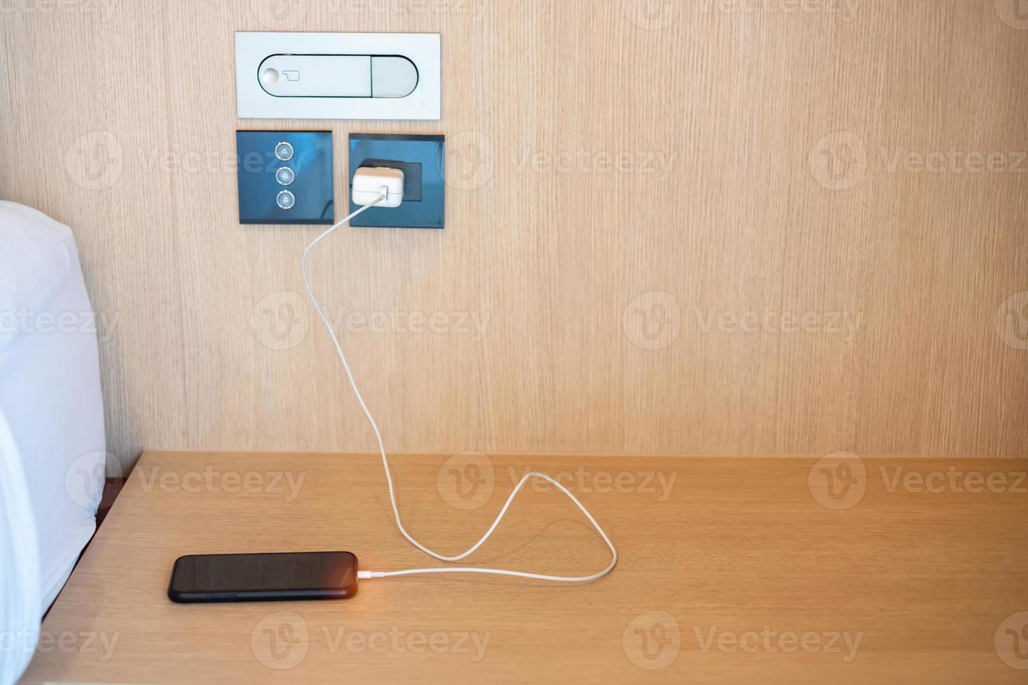 mobile smartphone charging battery on table at home or office. Technology, multiple sharing and recharge concepts photo