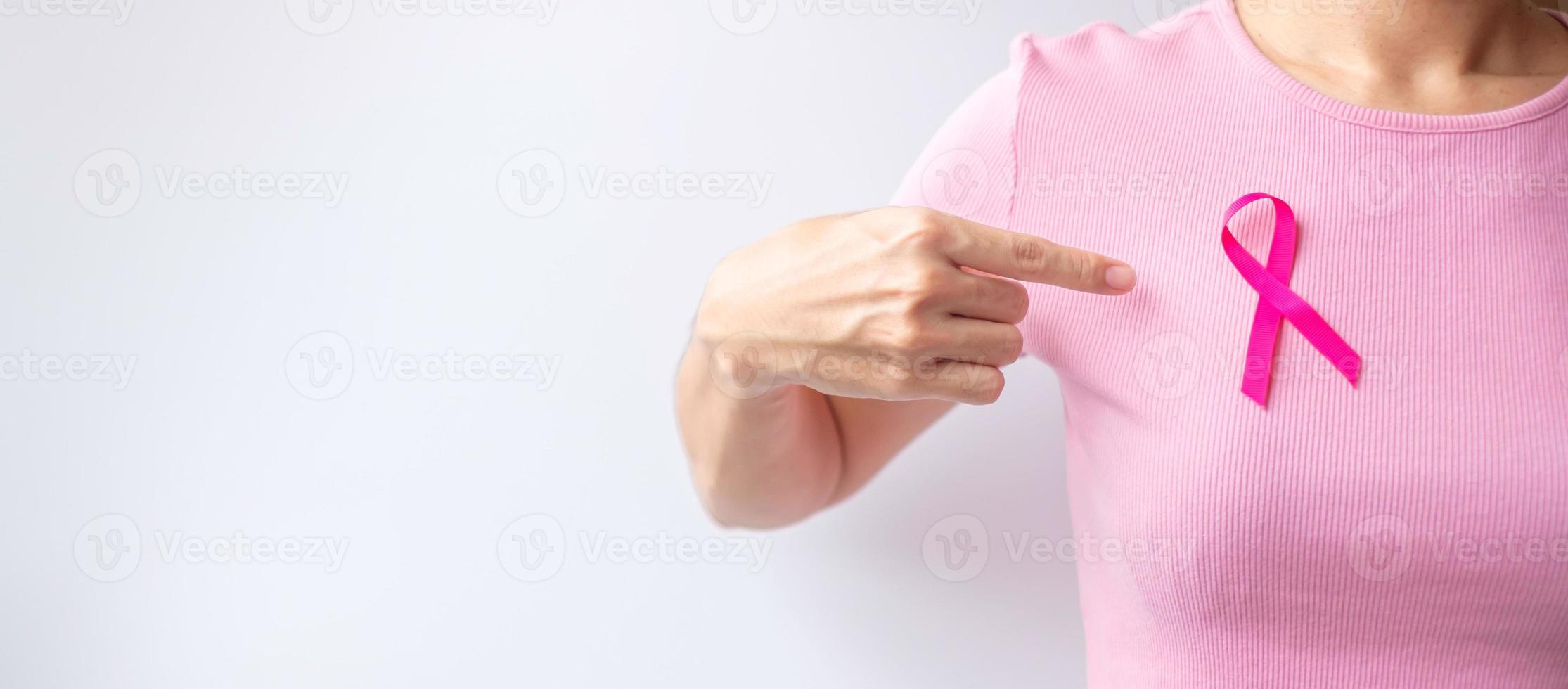 Pink October Breast Cancer Awareness month, woman hand hold pink Ribbon and wear shirt for support people life and illness. National cancer survivors month, Mother and World cancer day concept photo