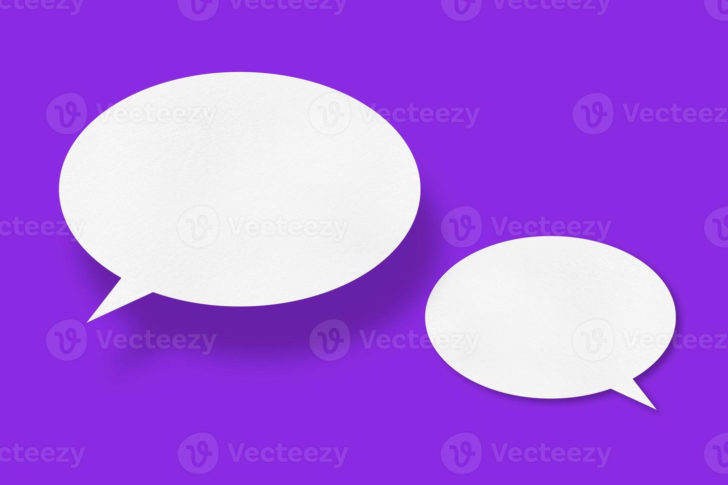 White paper in the shape of speech bubbles against a purple background. communication bubbles photo