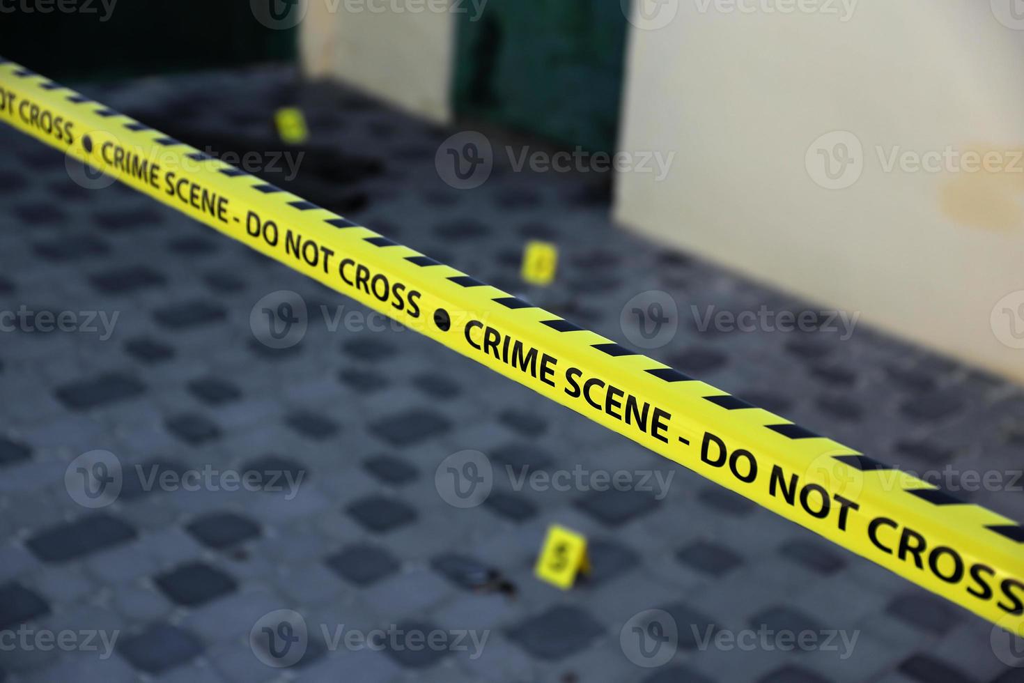 Crime scene tape for covering the area cordon. Yellow tape with blurred forensic law enforcement background in cinematic tone photo