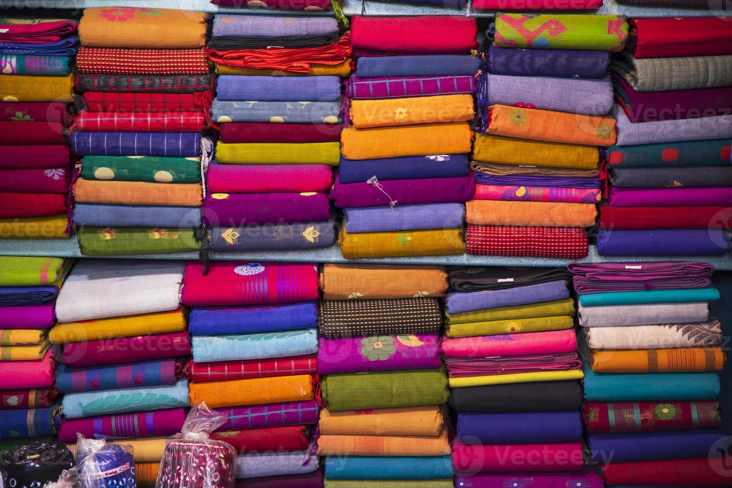 Artistic variety shade tone colors Saree's stacked on retail Shop Shelf to sale photo