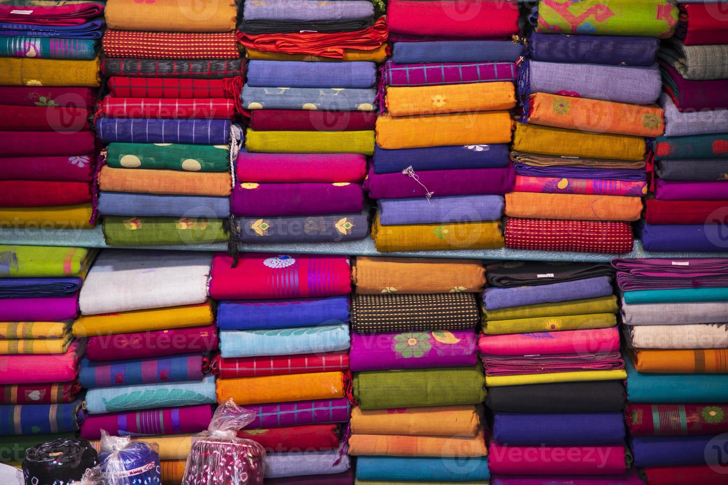 variedad artística colores de tono de sombra saris apilados en el estante de la tienda minorista para la venta foto