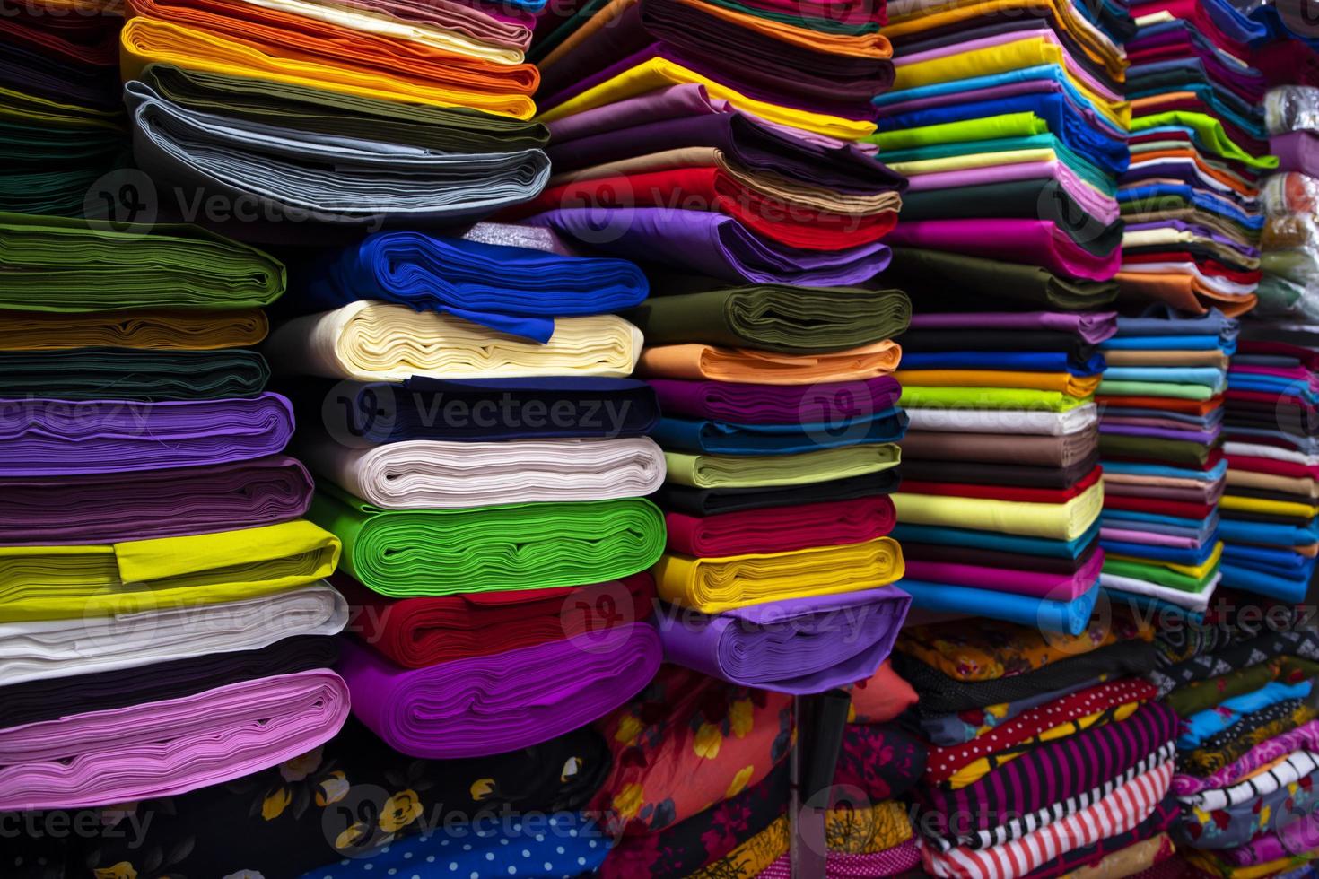 Artistic variety shade tone colors Textile Fabrics stacked on retail Shop Shelf to sale photo