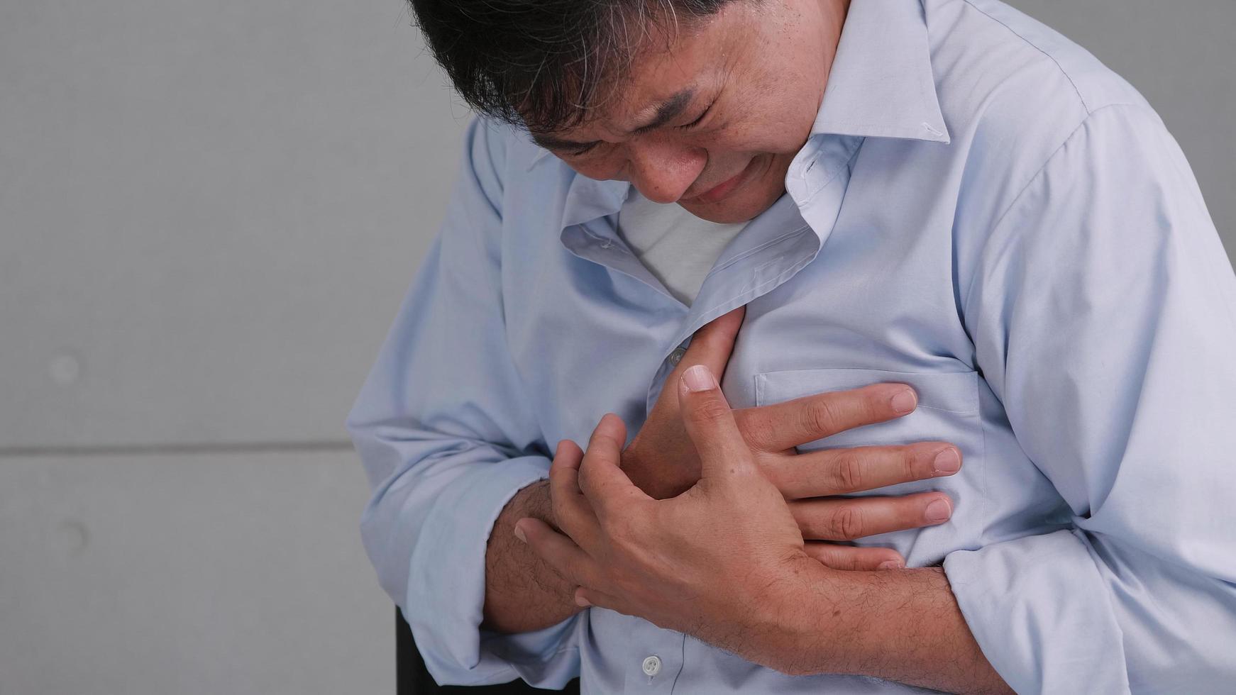 el hombre asiático tiene dolor en el pecho causado por una enfermedad cardíaca. foto