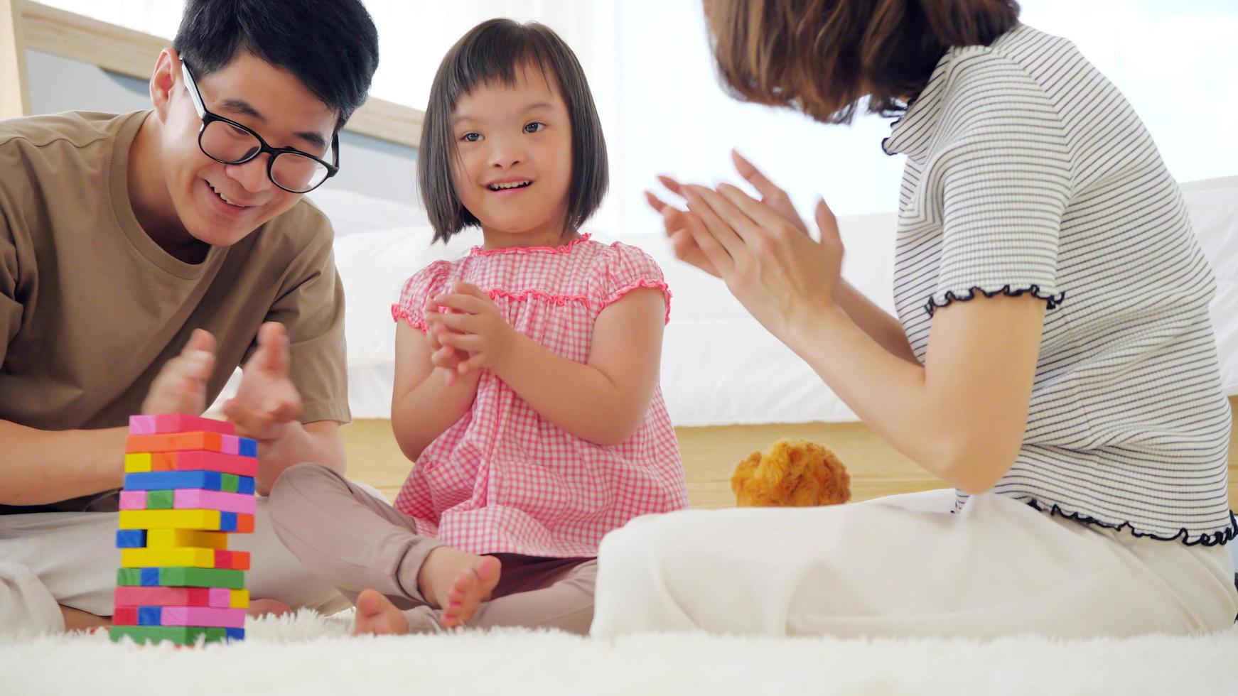 Happy family with mother, father and disabled daughter spending time together at home. photo