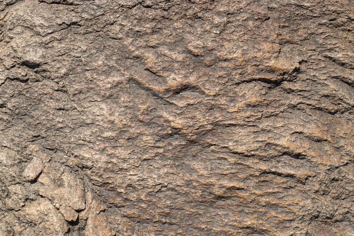 Raw granite rock texture background. Fragment of natural stone wall. photo