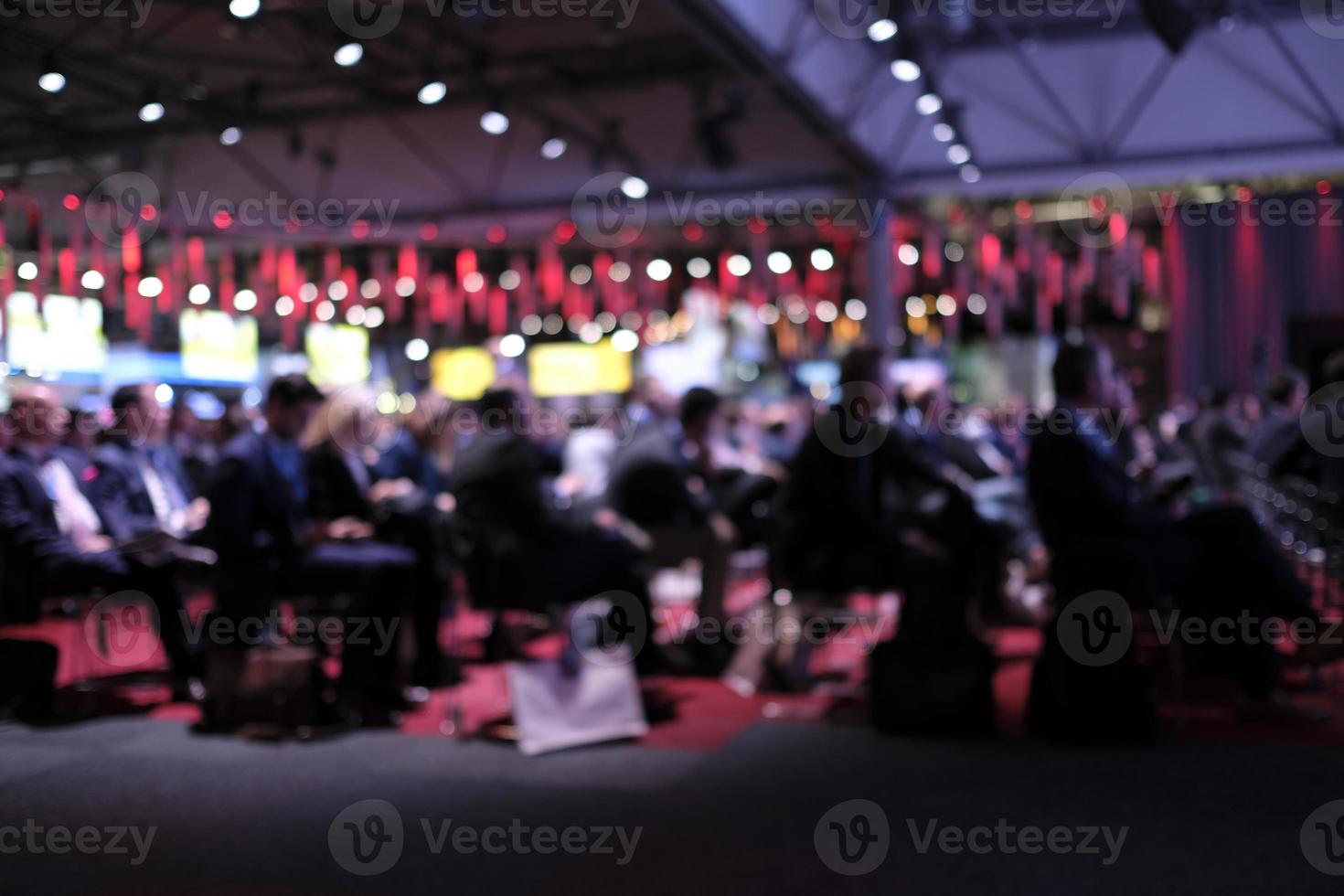 Anonymized photo with blurred out audience at a conference listening to a presentation