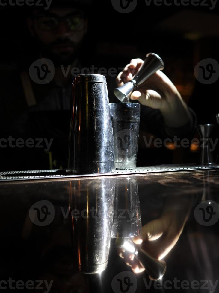 el camarero mezcla un hermoso cóctel en un vaso foto