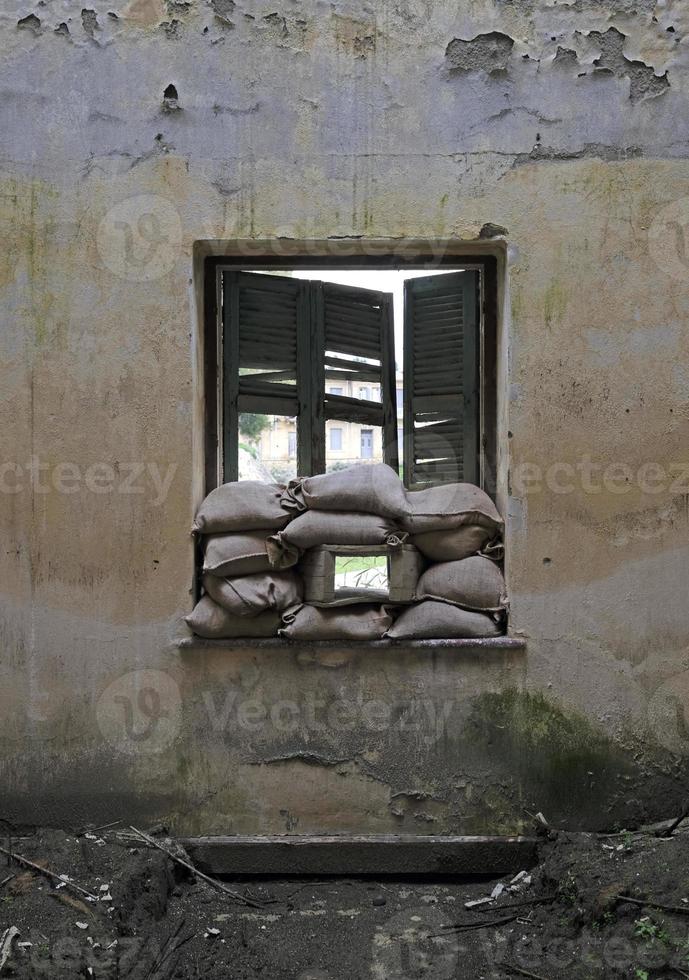 sacos de arena apilados en una ventana de una casa en la línea verde de la zona de amortiguamiento en nicosia, chipre foto