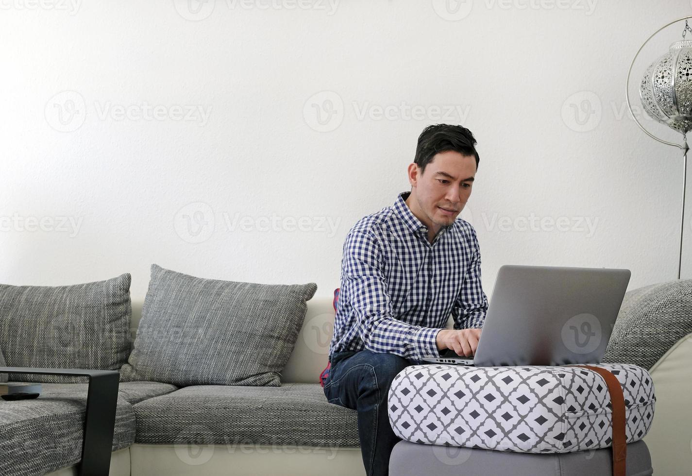Man working from home with a laptop in the living room photo