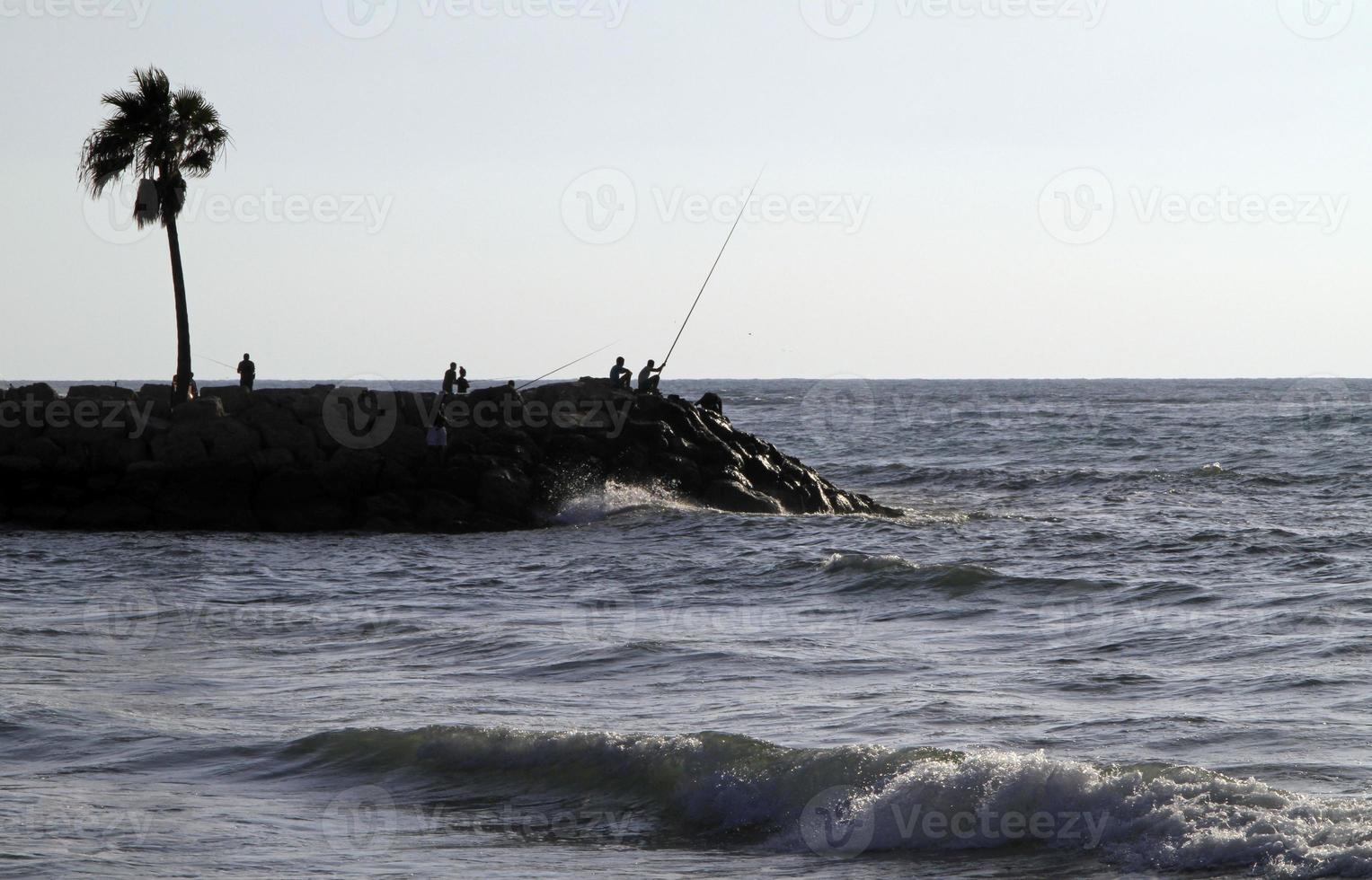 hombres en cuba pescando en la costa foto