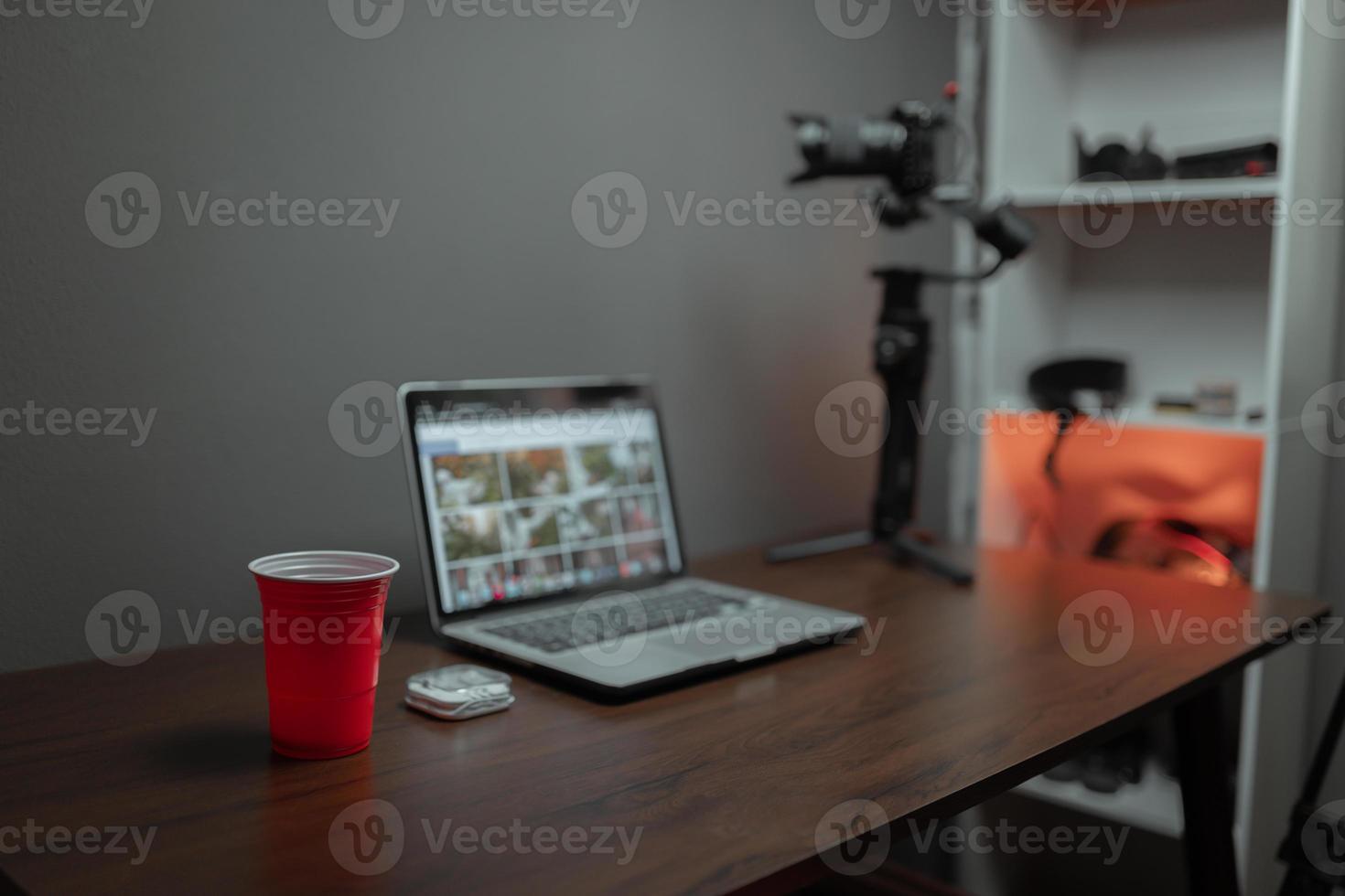 Desktop of the content creator with the laptop and red cup photo