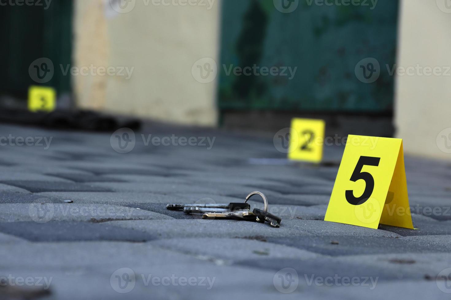 Evidence with yellow CSI marker for evidence numbering on the residental backyard in evening. Crime scene investigation concept photo