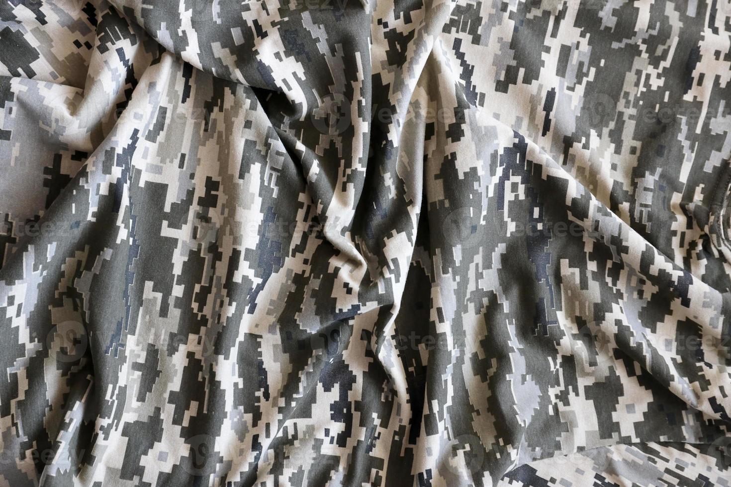 Fabric with texture of Ukrainian military pixeled camouflage. Cloth with camo pattern in grey, brown and green pixel shapes. Official uniform of Ukrainian soldiers photo