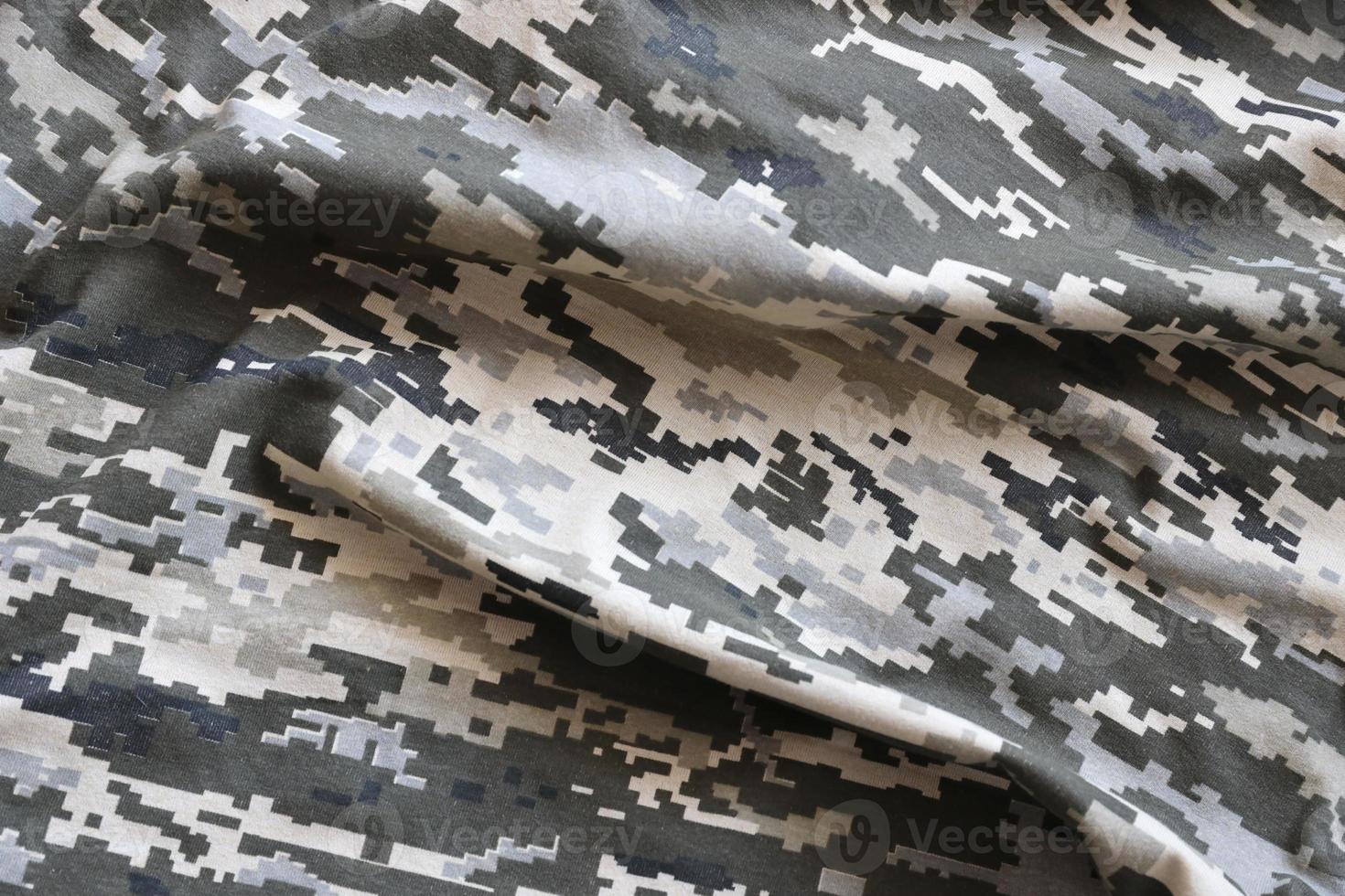 Fabric with texture of Ukrainian military pixeled camouflage. Cloth with camo pattern in grey, brown and green pixel shapes. Official uniform of Ukrainian soldiers photo