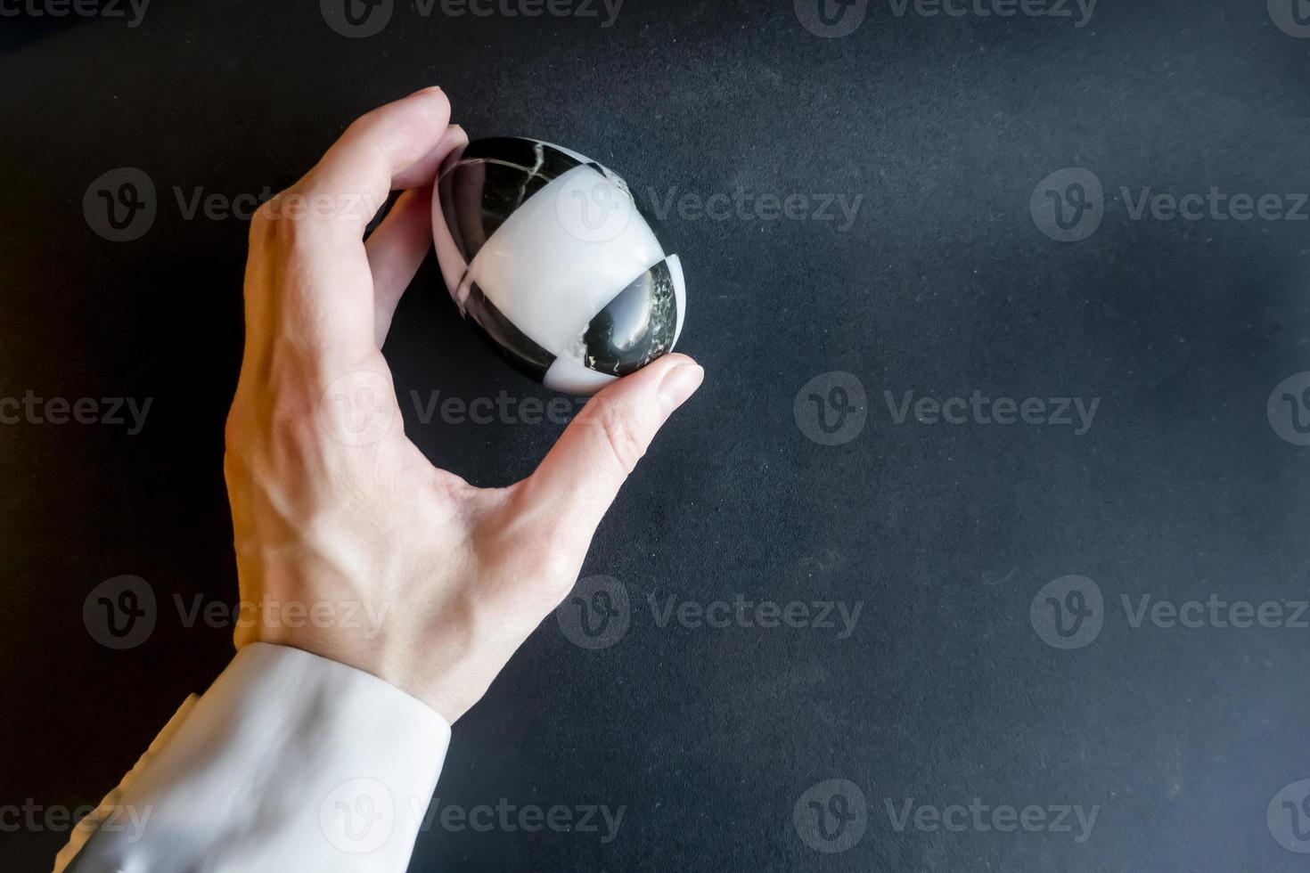 marble stone egg in hand on a black background. Easter theme photo