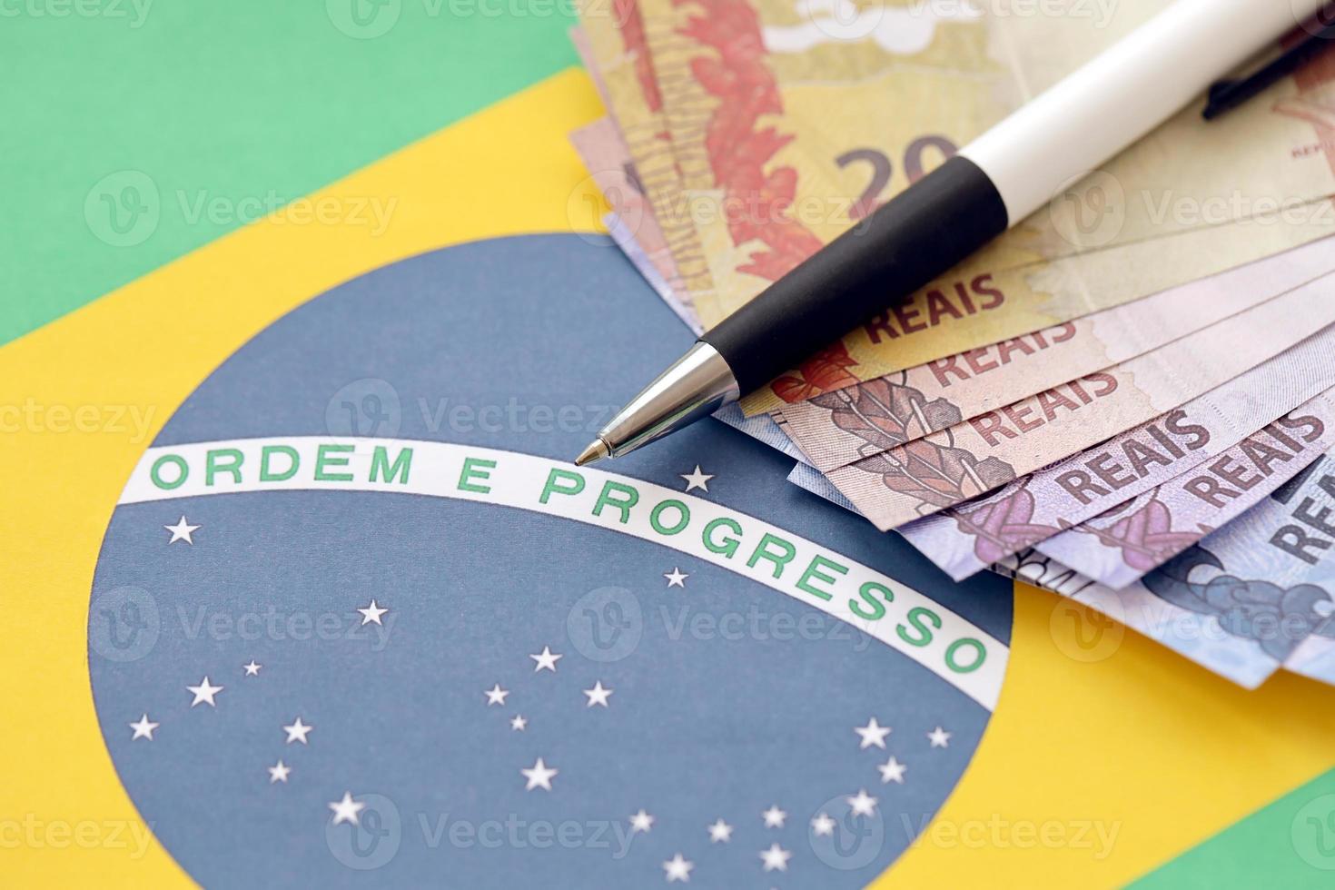 Pen with Brazilian money bills on blank of lottery game. Concept of luck and gambling in Brazil photo