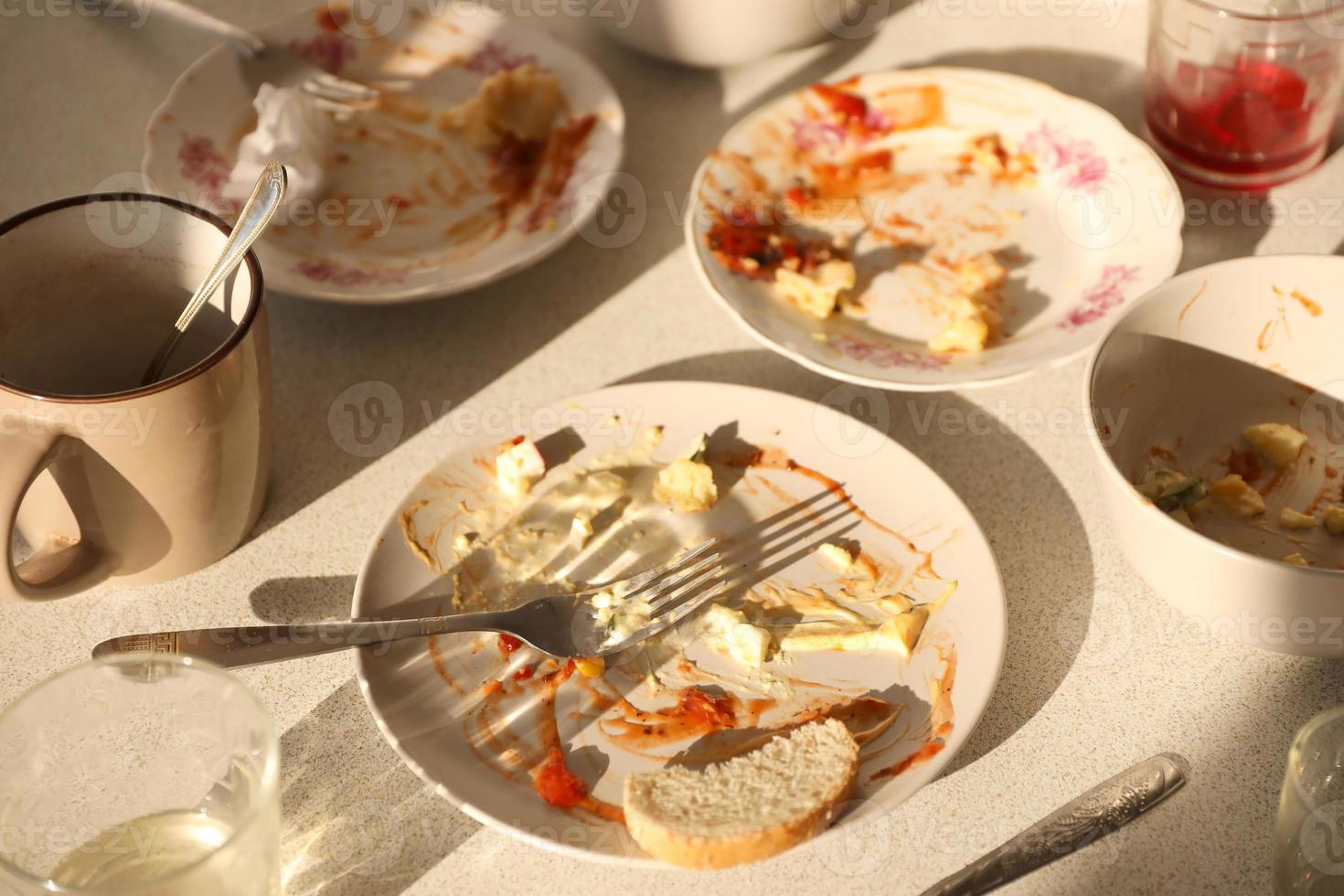 Empty dirty plates with spoons and forks on the table after meal. Banquet ending concept. Unwashed dishes photo