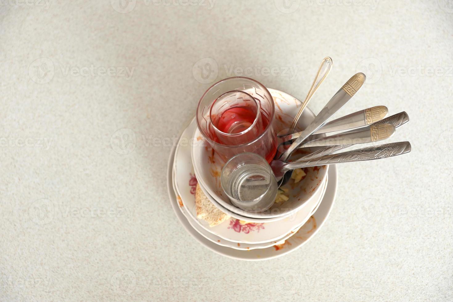 Stack of dirty dishes with food leftovers on the table after meal. Banquet ending concept. Unwashed dishes photo