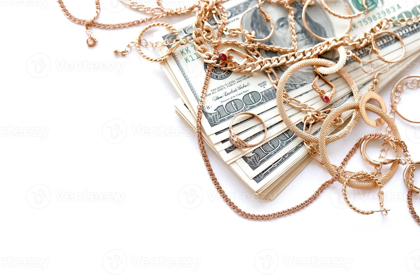 Many expensive golden jewerly rings, earrings and necklaces with big amount of US dollar bills on white background. Pawnshop or jewerly shop photo