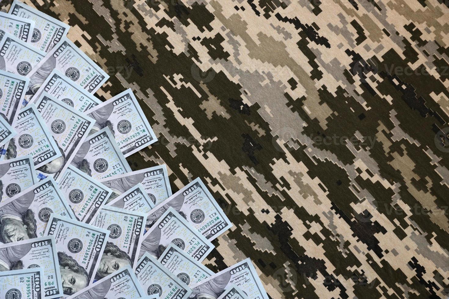 US dollar bills on fabric with texture of Ukrainian military pixeled camouflage. Cloth with camo pattern in grey, brown and green pixel shapes photo