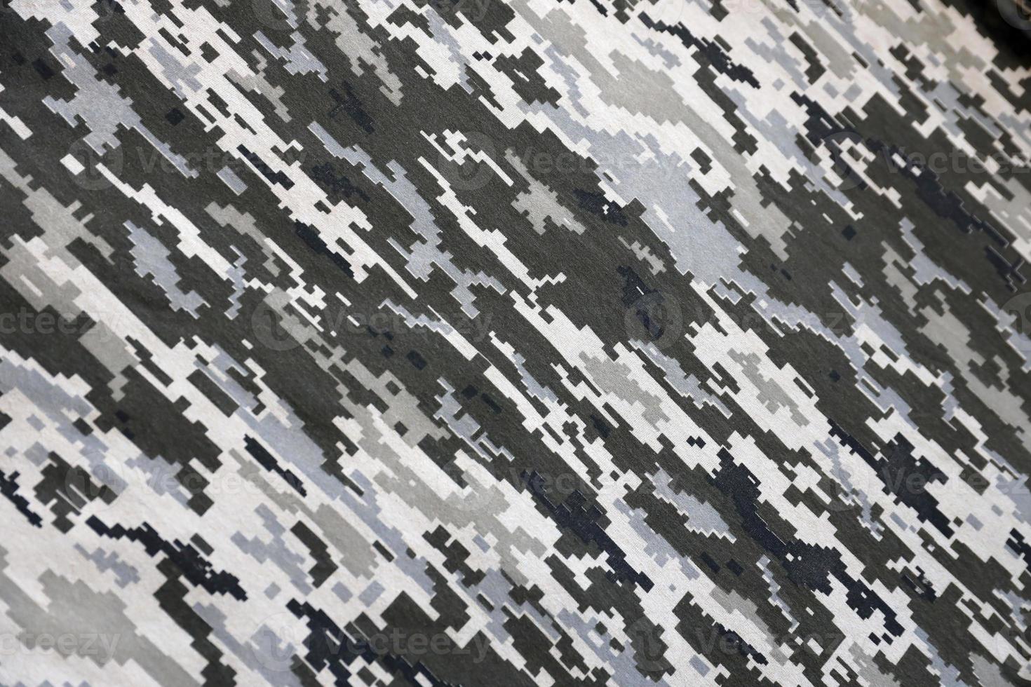 Fabric with texture of Ukrainian military pixeled camouflage. Cloth with camo pattern in grey, brown and green pixel shapes. Official uniform of Ukrainian soldiers photo